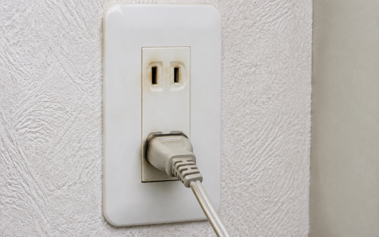 ほこりや水分が付着したコンセントまわりを確認するイメージ