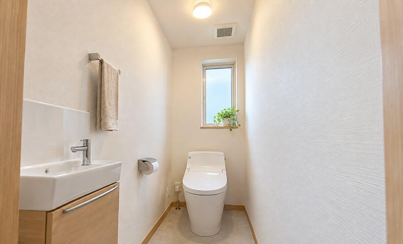 明るいトイレ照明と換気扇がある住宅のトイレのイメージ